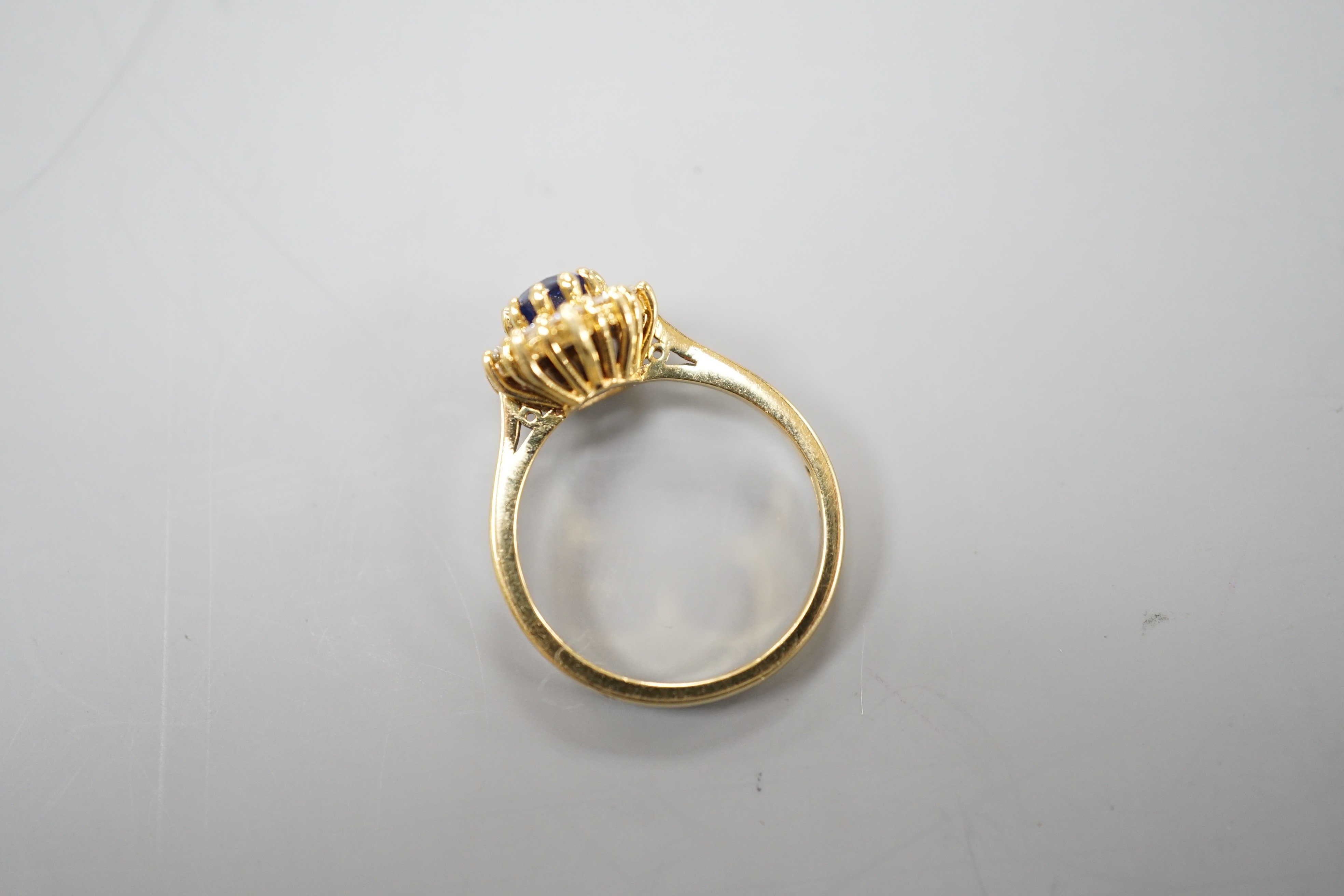 A modern 18ct gold, sapphire and diamond set oval cluster ring, size L, gross weight 3.8 grams